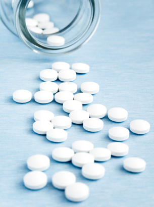 Glasburk innehållande tabletter som fallit och tabletter har runnot ur burken