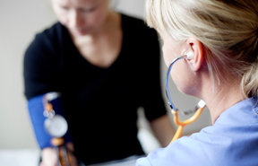 Foto på en sjuksköterska som tar blodtrycket på en patient. Foto: Sandra Lee Pettersson