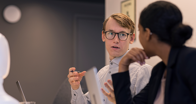 Två personer samtalar med varandra vid ett konferensbord. Foto: Plattform