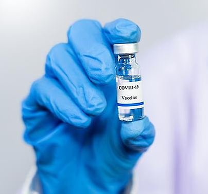 Bild på en hand som håller i en flaska med Covid-19 vaccin